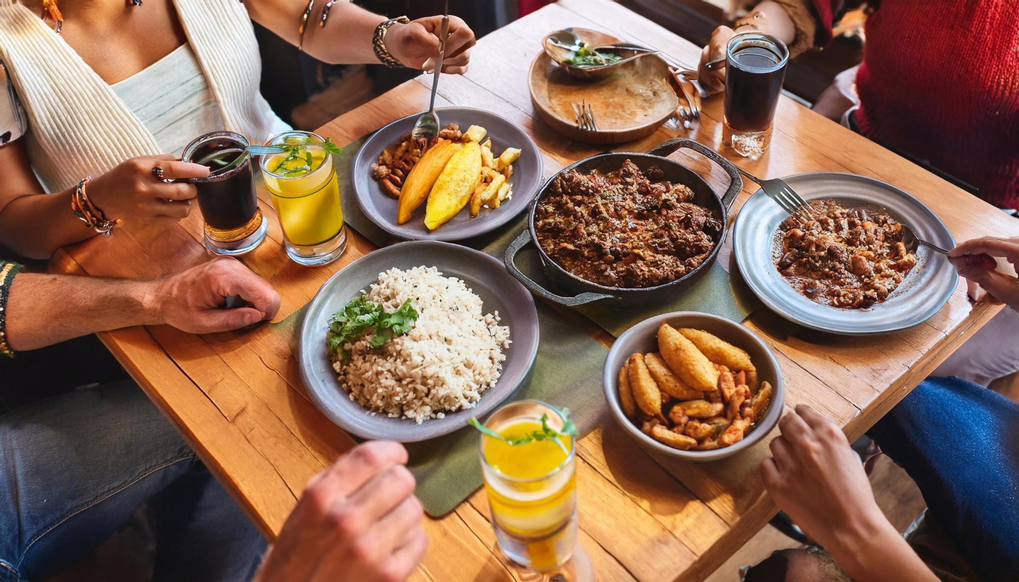 Mesa com comida e pessoas reunidas